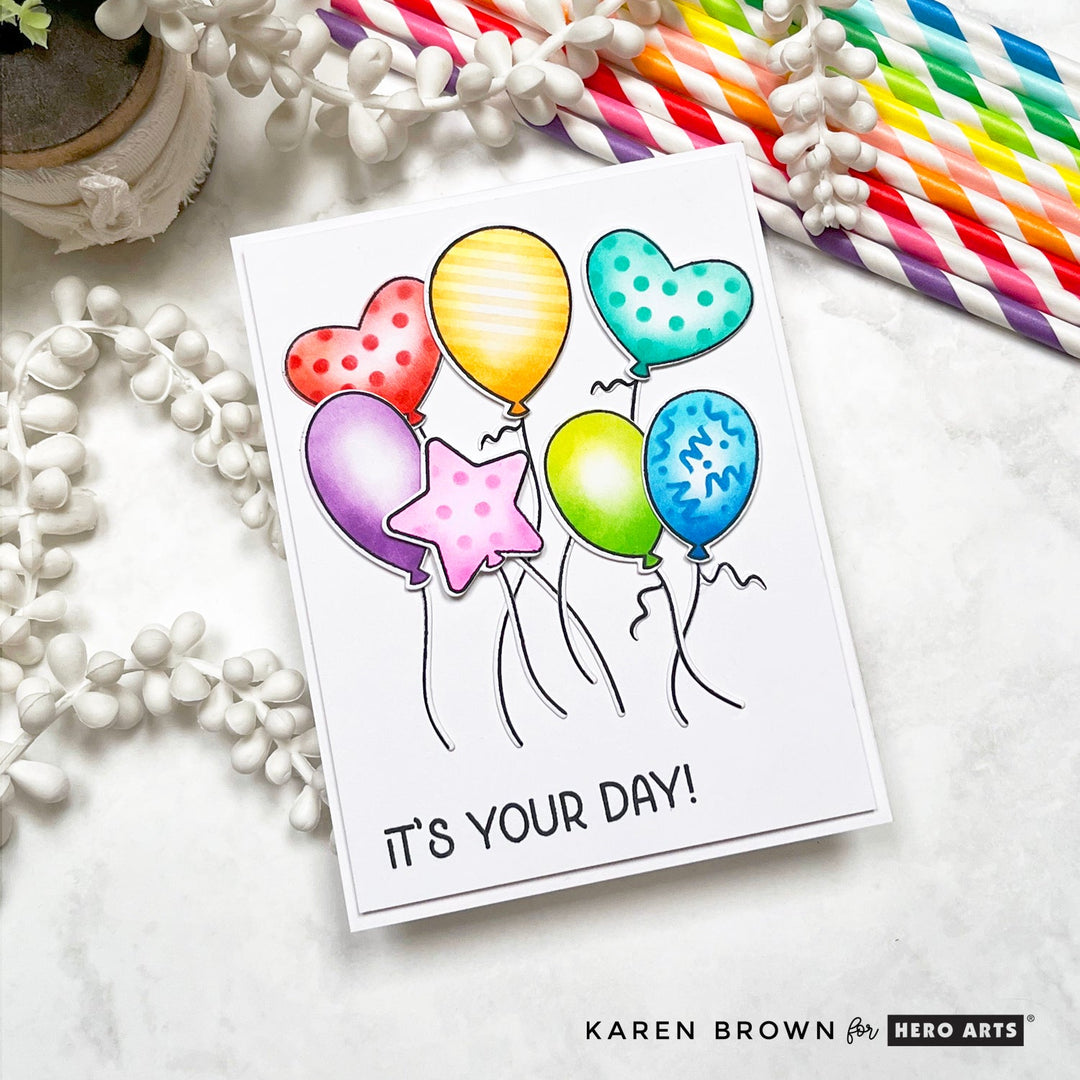A handmade card featuring 7 stamped , ink blended and stenciled floating, dancing balloons.